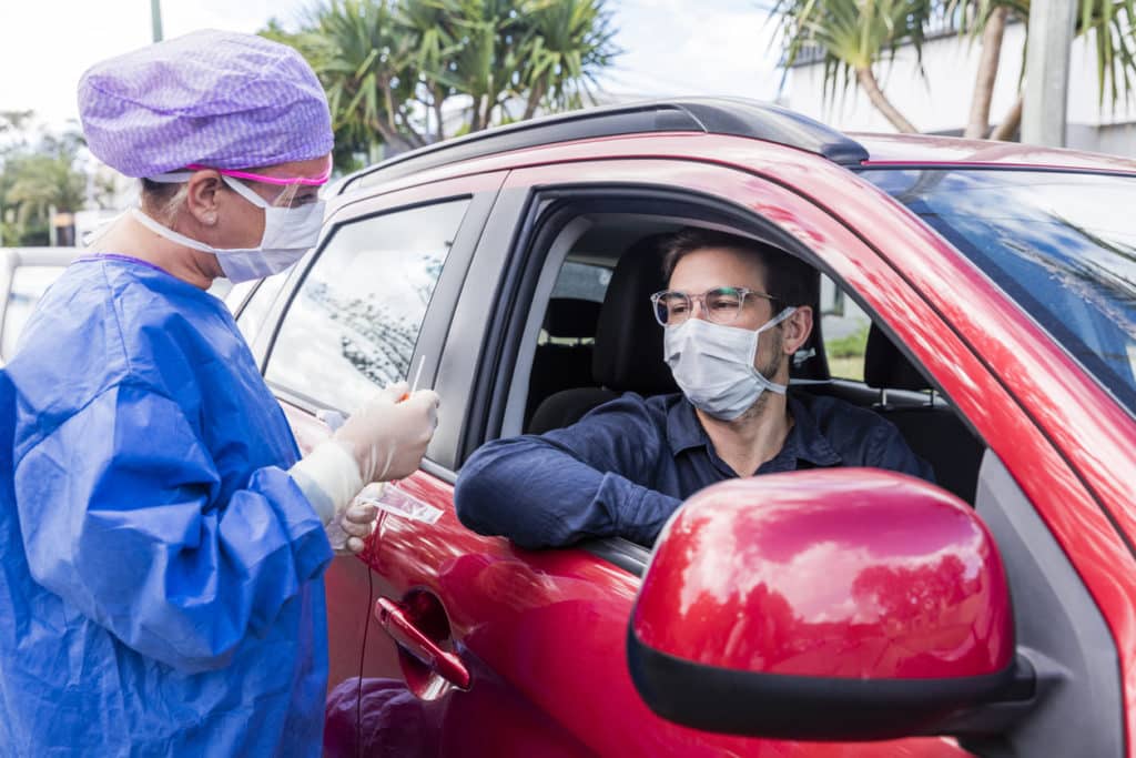 A doctor taking a nasal swab from a driver A doctor taking a nasal swab from a driver